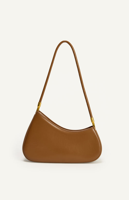 Shweetcheeks asymmetrical curved shoulder bag in smooth caramel vegan leather with gold hardware detailing