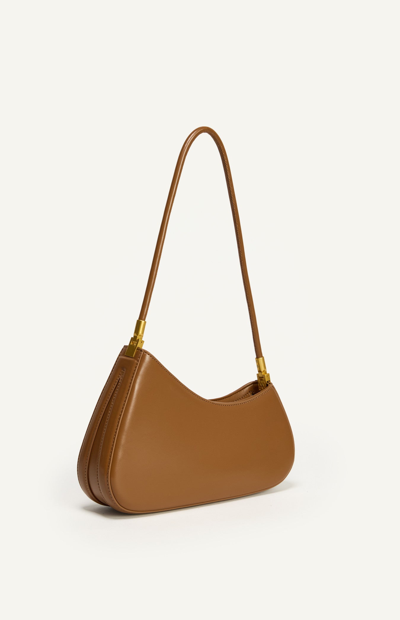Shweetcheeks asymmetrical curved shoulder bag in smooth Caramel vegan leather with gold hardware detailing