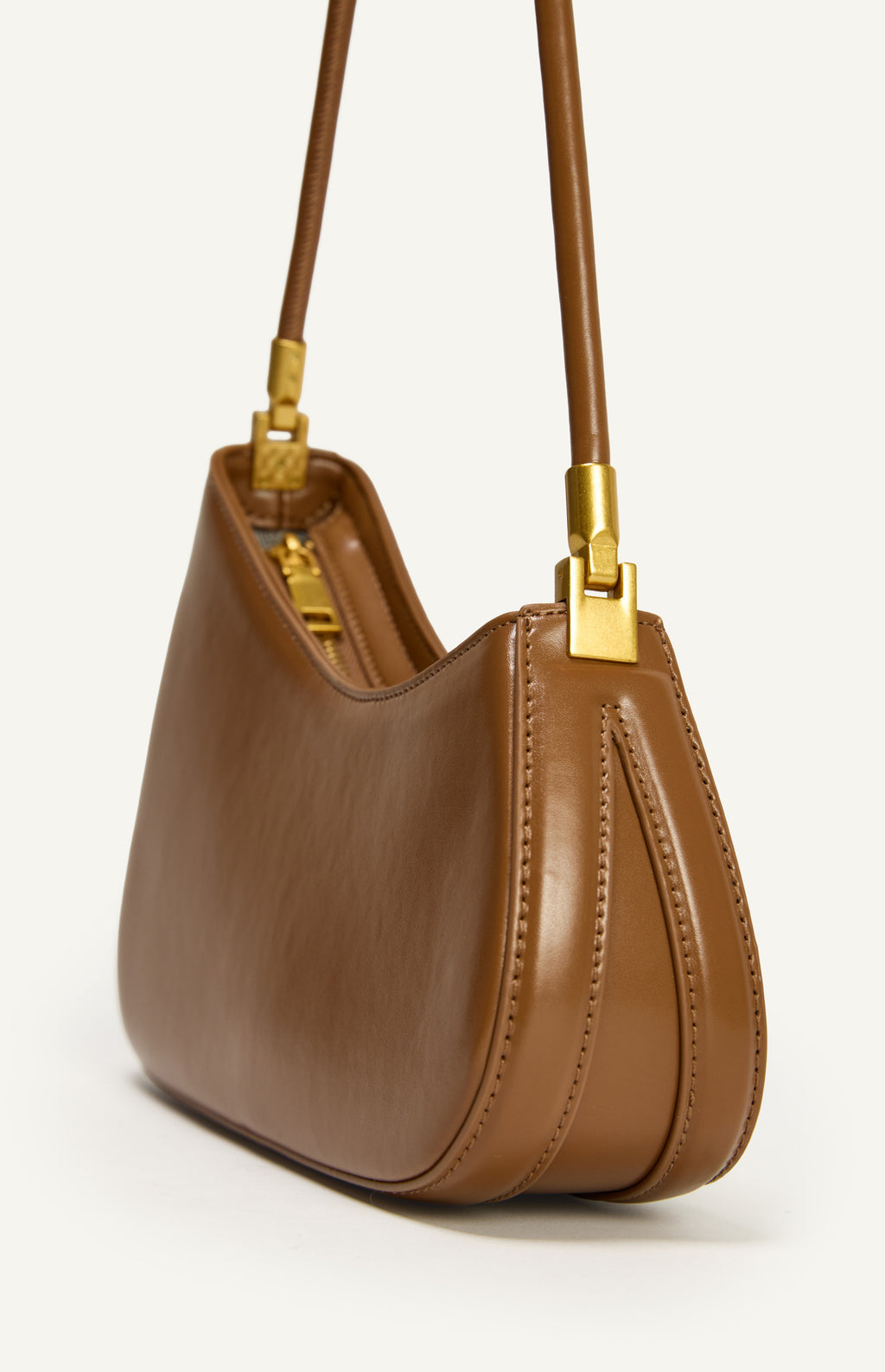 Caramel  leather handbag with gold accents on a white background